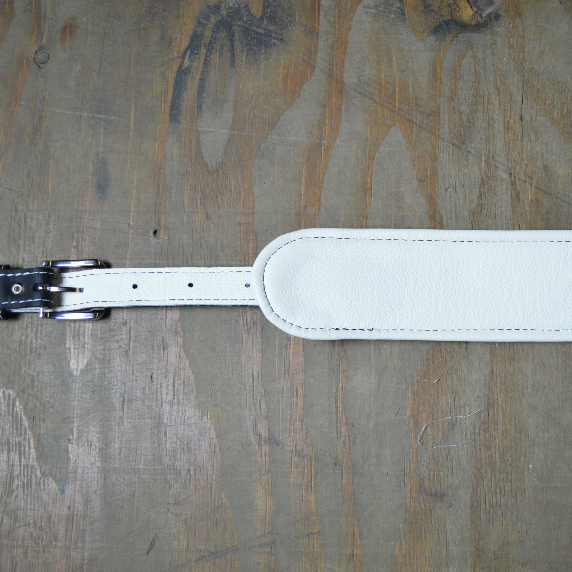 Vintage style guitar strap made with a topgrain leather top and an upholstery backing. Black & White